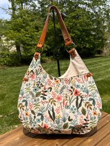 Close up of the Compass Rose Shoulder bag showing the Rifle Paper Co. Herb Garden Natural Canvas with Cognac Leather.