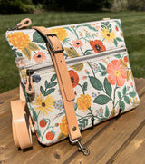 Handcrafted Rifle Paper Co. Canvas Bayside Slim Crossbody Bag in Natural Botanical Floral Canvas with cotton canvas lining and adjustable Splenda vegetable-tanned leather strap.