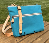 Front View Handcrafted Canvas Bayside Slim Crossbody Bag in Teal canvas with cotton canvas lining and adjustable Splenda vegetable-tanned leather strap. Lightweight and perfect for everyday wear.