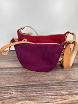 Group of Canvas Windward Sling,  Burgundy Canvas with Natural Splenda Leather Strap and Antique Brass Hardware and a Large Scarlet Canvas with Natural Splenda Leather Strap and Antique Brass Hardware.