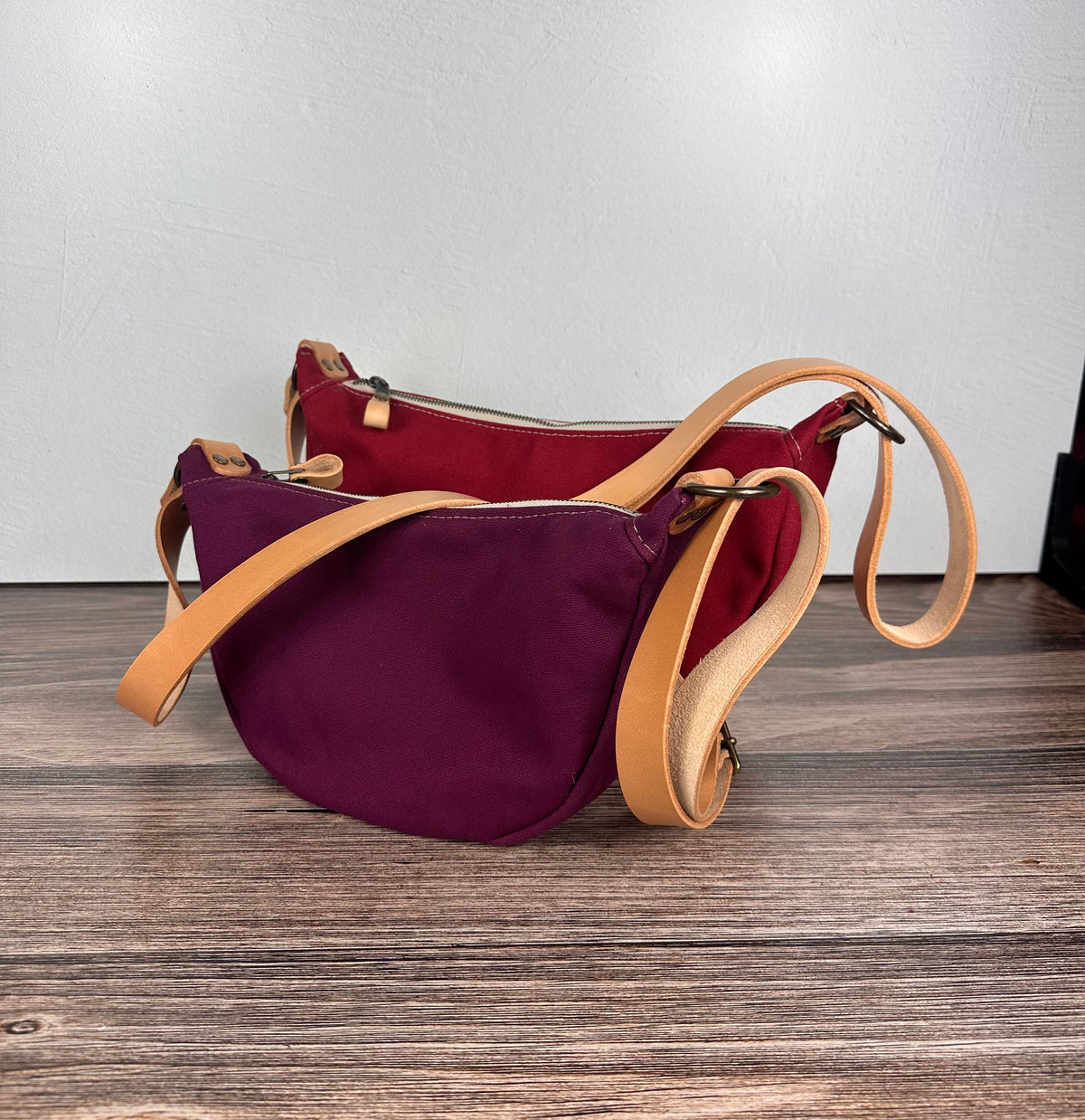 Group of Canvas Windward Sling,  Burgundy Canvas with Natural Splenda Leather Strap and Antique Brass Hardware and a Large Scarlet Canvas with Natural Splenda Leather Strap and Antique Brass Hardware.