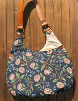 View of the Compass Rose Shoulder Bag in Rifle Paper Co. Wildwood Peonies Blue Canvas with Cognac Leather.