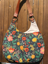 View of the Compass Rose Shoulder Bag in Rifle Paper Navy Botanical Floral Canvas with Cherry Leather,