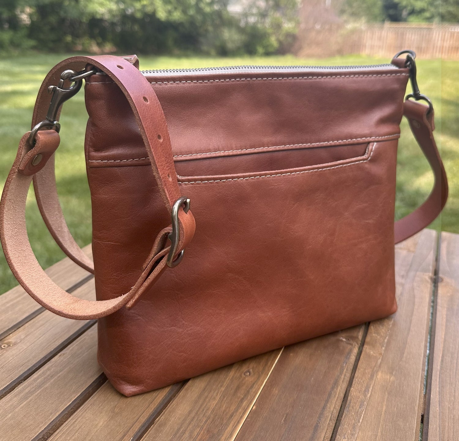 Front view of a handcrafted Leather Bayside Crossbody bag in Sienna Horween leather, showcasing its rich, warm color, natural grain, solid brass hardware, and full metal zipper. Designed and made in Maryland.