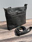 Front view of a handcrafted Leather Bayside Crossbody bag in Rustic Charcoal Horween leather, showcasing its rich, warm color, natural grain, solid brass hardware, and full metal zipper. Designed and made in Maryland.