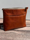 Front view of a handcrafted Leather Bayside Crossbody bag in Sienna Horween leather, showcasing its rich, warm color, natural grain, solid brass hardware, and full metal zipper. Designed and made in Maryland.
