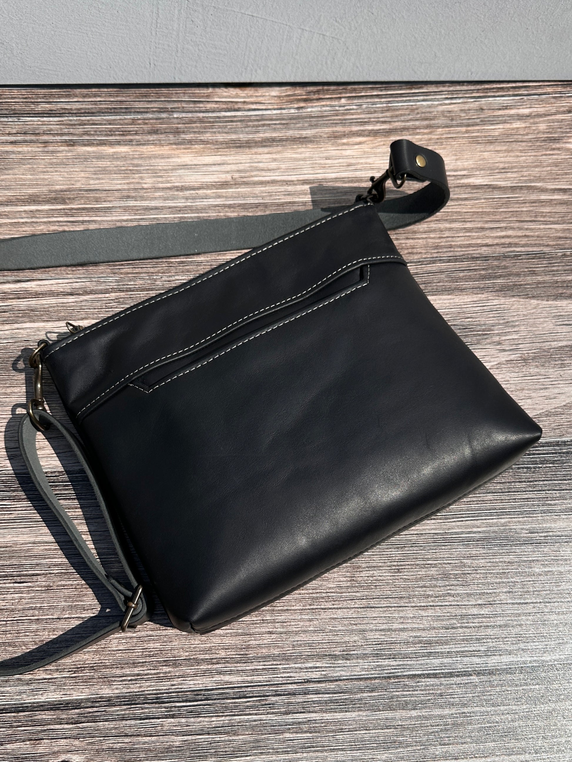 Bomber Jacket Black Horween leather, showcasing its rich, warm color, natural grain, solid brass hardware, and full metal zipper. Designed and made in Maryland.