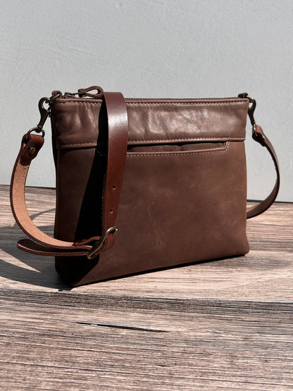 Front view of a handcrafted Leather Bayside Crossbody bag in Vintage Dark Brown Horween leather, showcasing its rich, warm color, natural grain, solid brass hardware, and full metal zipper. Designed and made in Maryland.