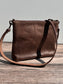 Back view of a handcrafted Leather Bayside Crossbody bag in Vintage Dark Brown Horween leather, showcasing its rich, warm color, natural grain, solid brass hardware, and full metal zipper. Designed and made in Maryland.