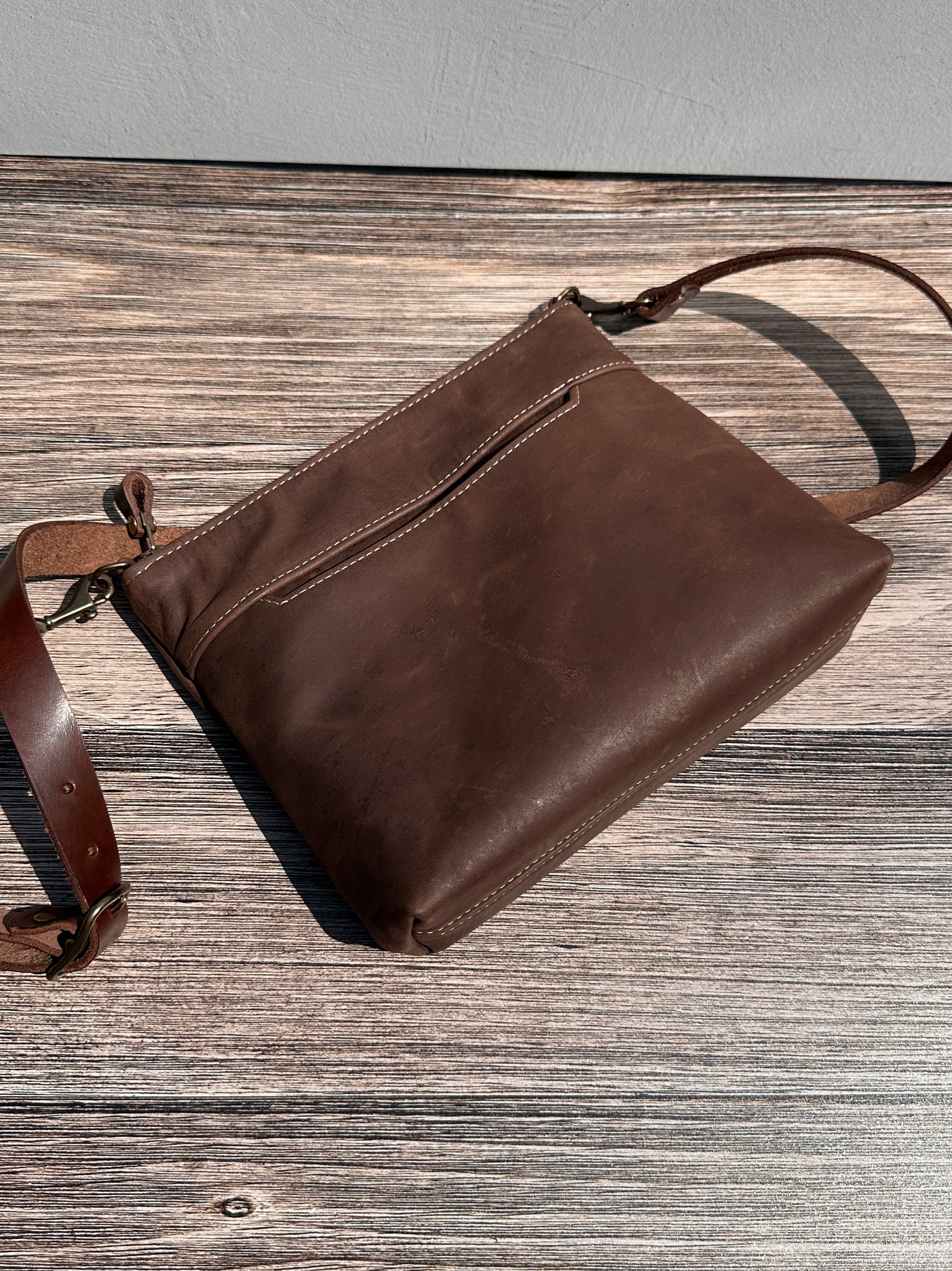 Vintage Dark Brown Leather Horween leather, showcasing its rich, warm color, natural grain, solid brass hardware, and full metal zipper. Designed and made in Maryland.