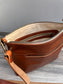 Front open view of a handcrafted Leather Bayside Crossbody bag in Sienna Horween leather, showcasing its rich, warm color, natural grain, solid brass hardware, and full metal zipper. Designed and made in Maryland.