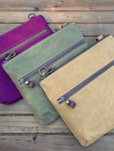 Collection of handcrafted Canvas Bayside Slim Crossbody Bags in  waxed canvas, and solid canvas styles, with full canvas lining and adjustable vegetable-tanned leather straps.