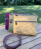Collection of handcrafted Canvas Bayside Slim Crossbody Bags in waxed canvas, and solid canvas styles, with full canvas lining and adjustable vegetable-tanned leather straps.