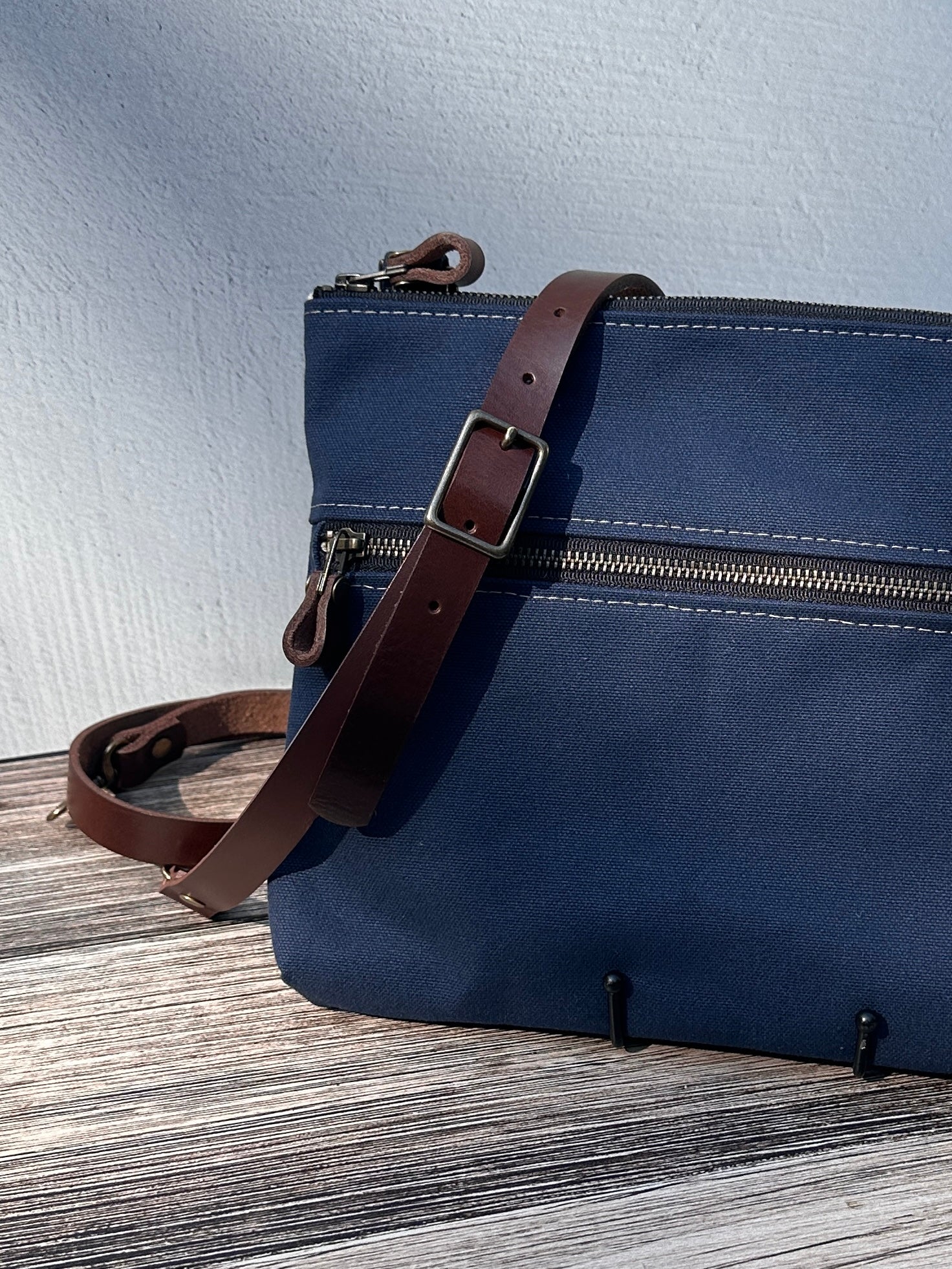 Up Close Front View Handcrafted Canvas Bayside Slim Crossbody Bag in Navy 18 oz canvas with cotton canvas lining and adjustable Splenda vegetable-tanned leather strap. Lightweight and perfect for everyday wear.