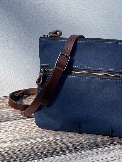 Up Close Front View Handcrafted Canvas Bayside Slim Crossbody Bag in Navy 18 oz canvas with cotton canvas lining and adjustable Splenda vegetable-tanned leather strap. Lightweight and perfect for everyday wear.