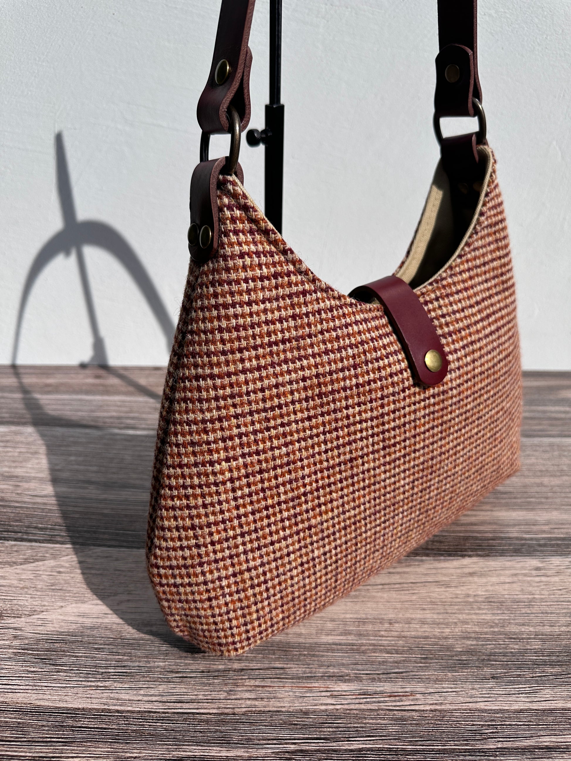 Close up view Fawn & Amber Harris Tweed® Rhode River Shoulder Bags,  Bordeaux Leather with Antique Brass Hardware. Handcrafted in Maryland