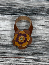 Close-up of leather flower purse charm with snap closure.