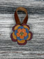 Close-up of leather flower purse charm with snap closure.