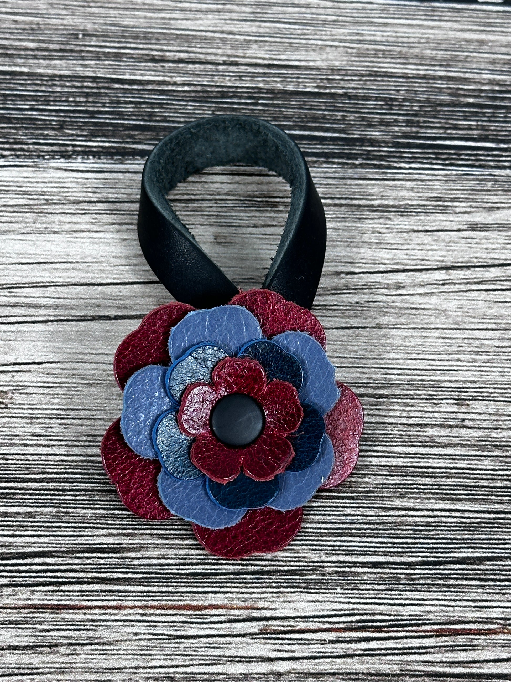 Close-up of leather flower purse charm with snap closure.