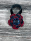 Close-up of leather flower purse charm with snap closure.