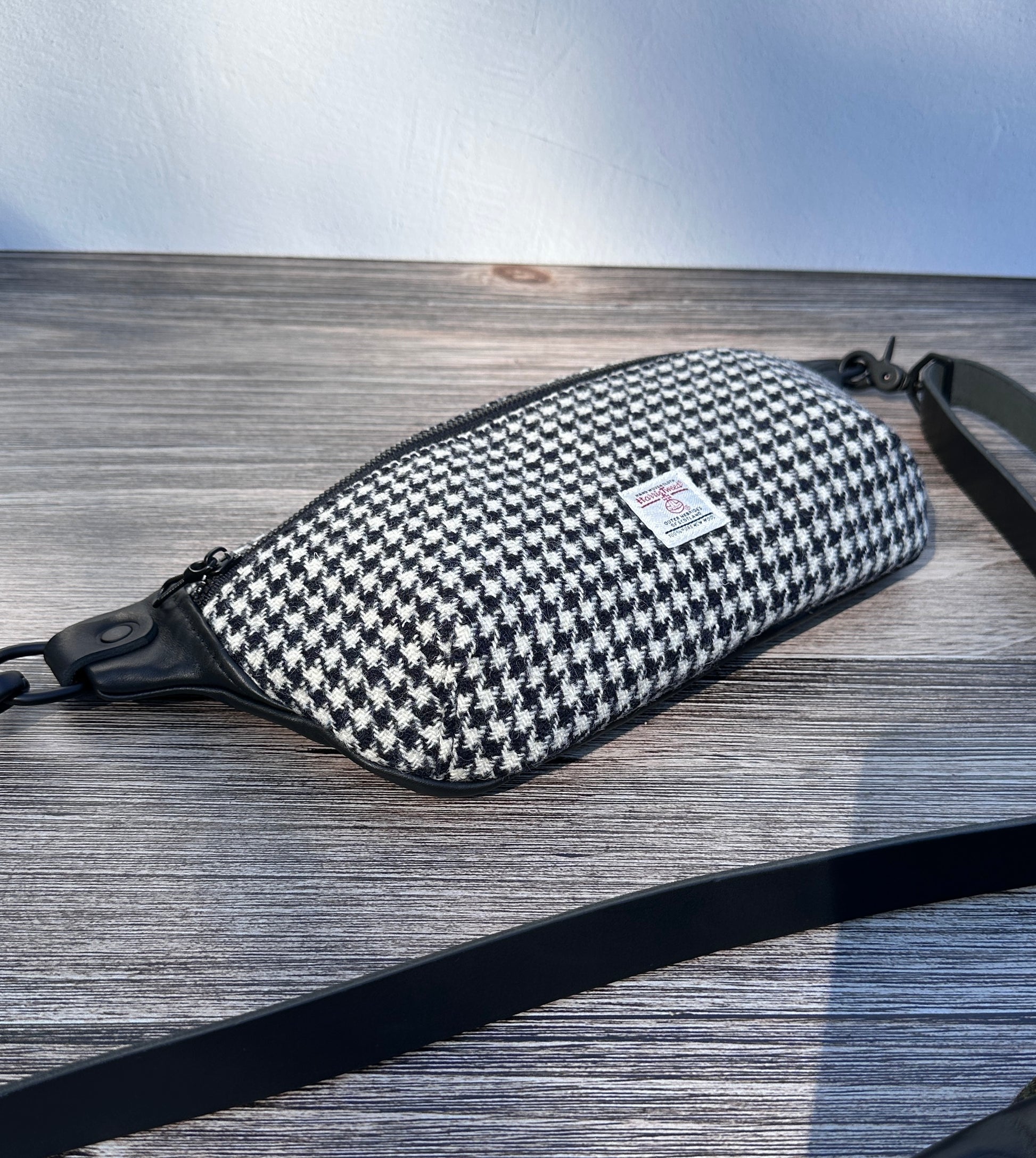 Minimalist sling bag handcrafted with Black and White Houndstooth Harris Tweed® and Horween Black Leather, finished with Matte Black hardware.