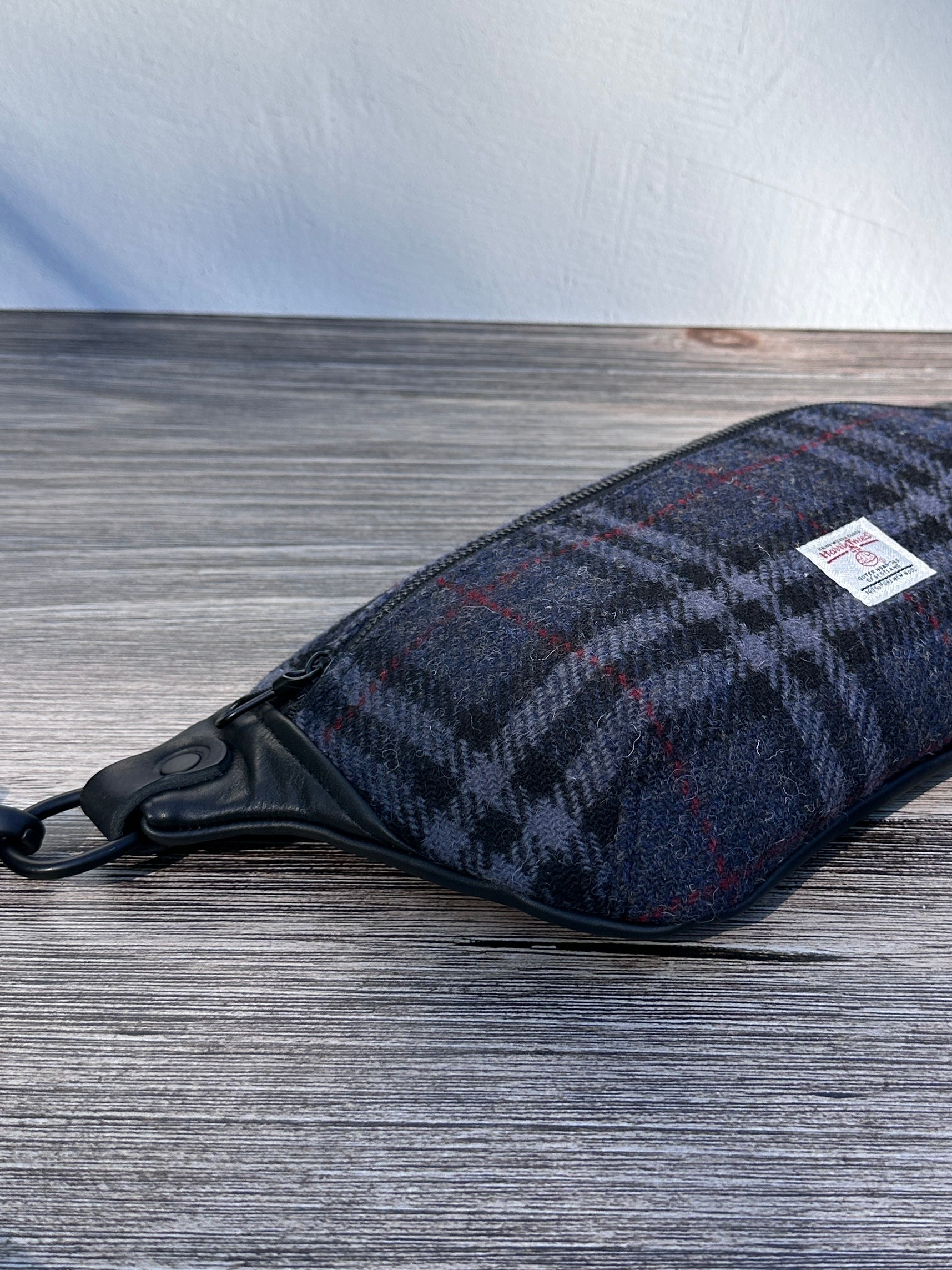 Minimalist sling bag handcrafted with Blue, Black and Grey plaid Harris Tweed® and Horween Black Leather, finished with Matte Black hardware.