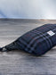 Minimalist sling bag handcrafted with Blue, Black and Grey plaid Harris Tweed® and Horween Black Leather, finished with Matte Black hardware.