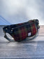 Minimalist sling bag handcrafted with Green, Red, Black plaid Harris Tweed® and Horween Black Leather, finished with Antique Brass hardware.