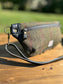 Minimalist sling bag handcrafted with Olive plaid Harris Tweed® and Horween Black Leather, finished with Antique Brass hardware.