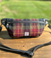 Minimalist sling bag handcrafted with Green, Red and Black plaid Harris Tweed® and Horween Black Leather, finished with Antique Brass  hardware.