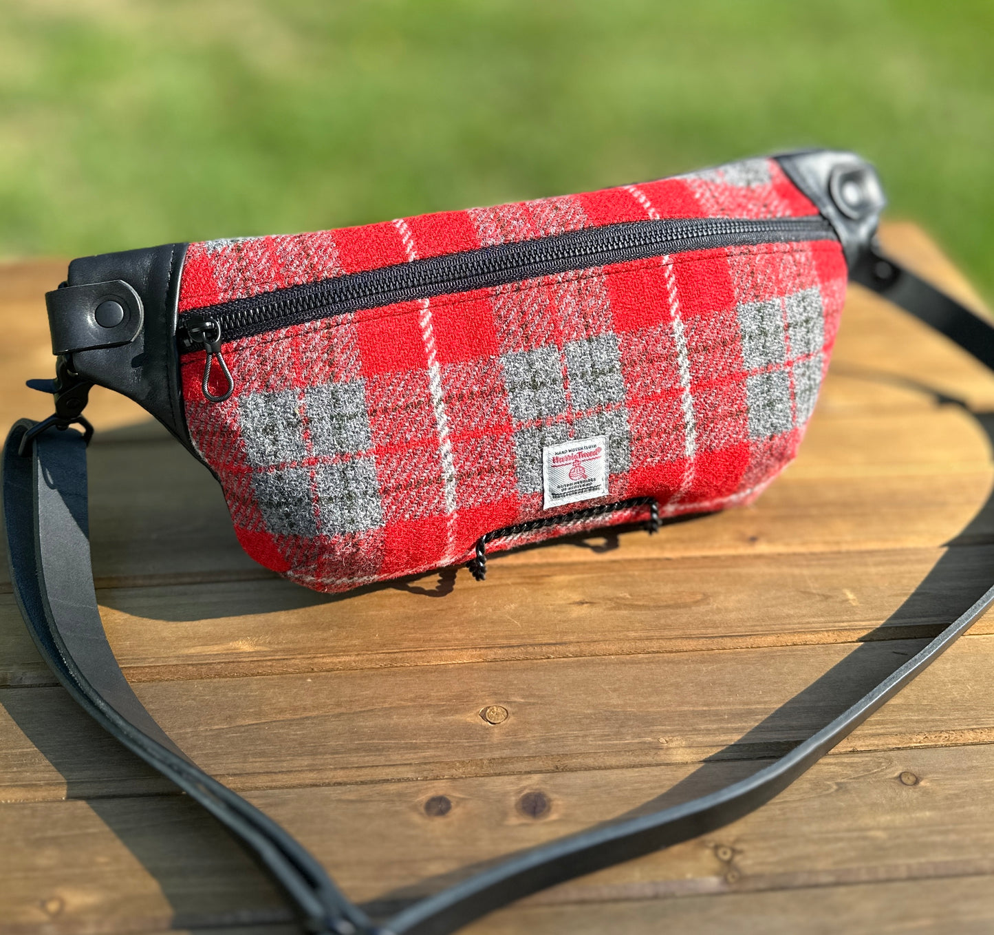 Minimalist sling bag handcrafted with Red and gray plaid Harris Tweed® and Horween Black Leather, finished with Matte Black hardware.