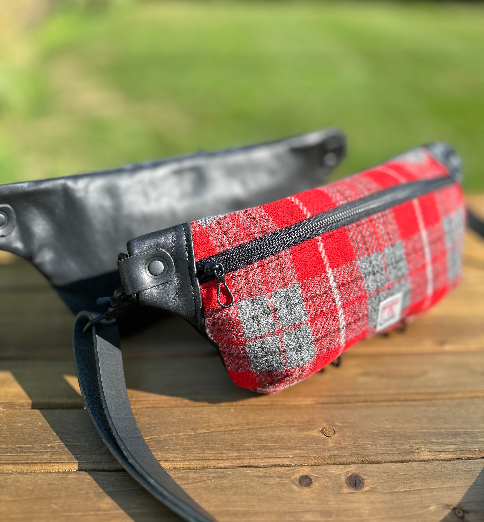 Minimalist sling bag handcrafted with Red and gray plaid Harris Tweed® and Horween Black Leather, finished with Matte Black hardware.