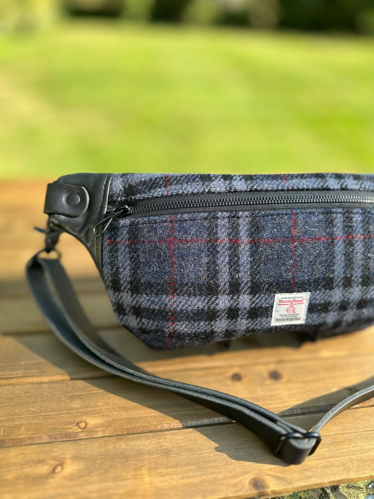 Minimalist sling bag handcrafted with Blue, Black and Grey plaid Harris Tweed® and Horween Black Leather, finished with Matte Black hardware.