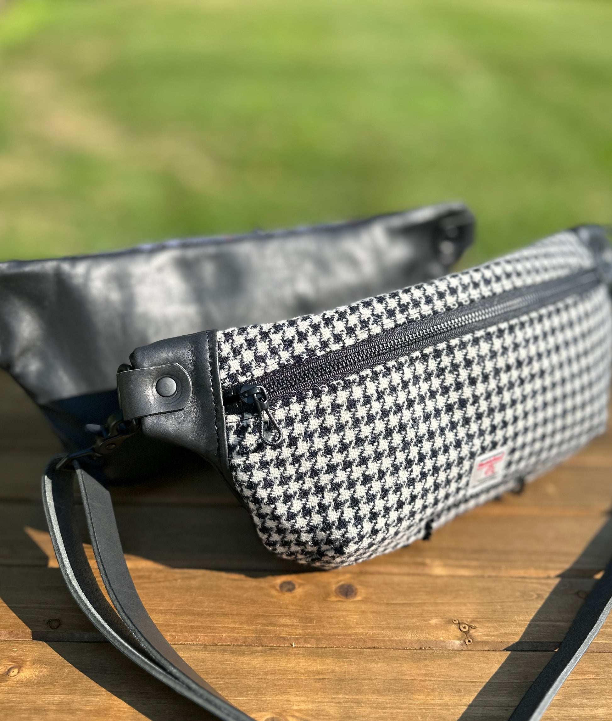 Minimalist sling bag handcrafted with Black and White Houndstooth Harris Tweed® and Horween Black Leather, finished with Matte Black hardware.