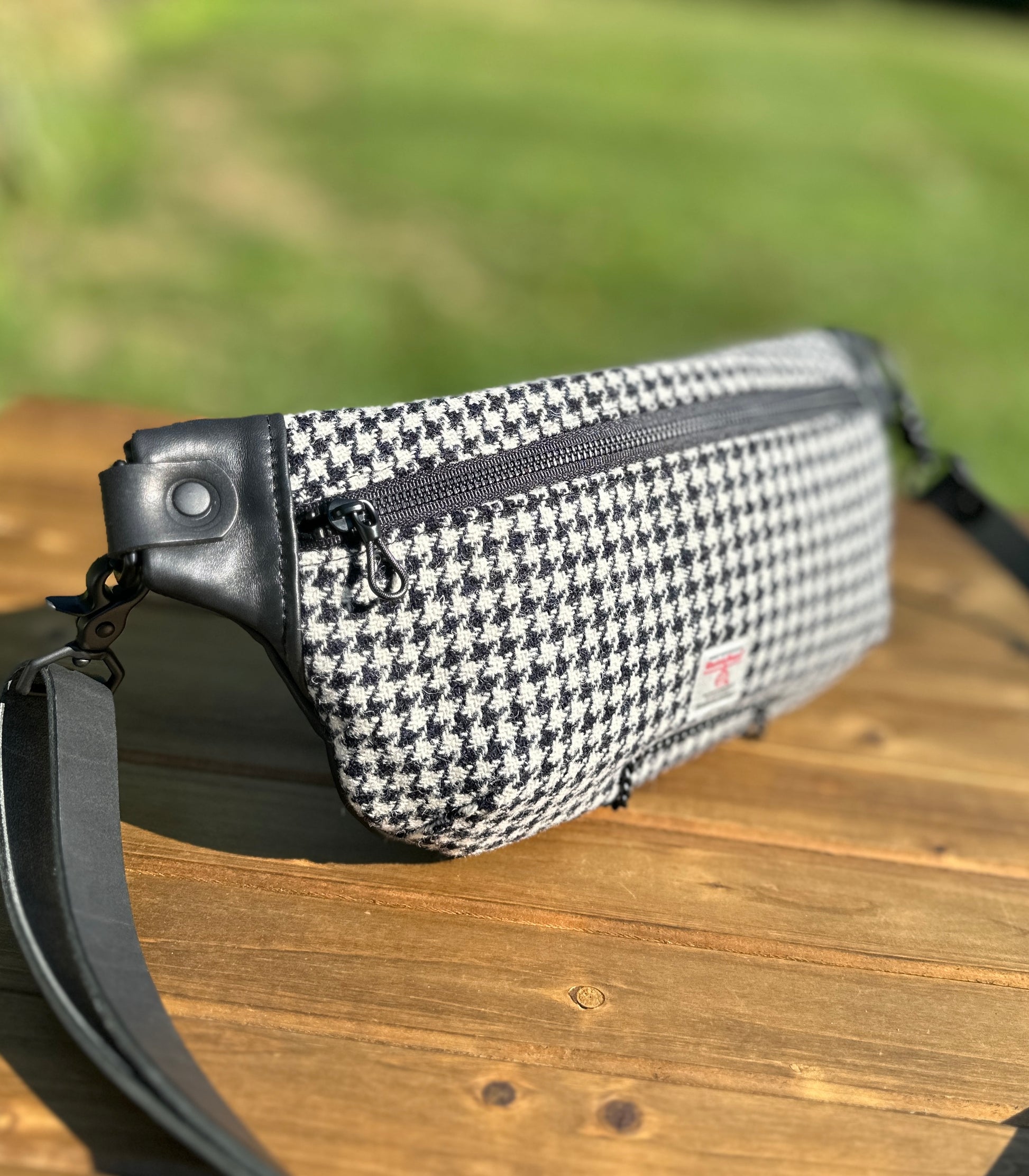 Minimalist sling bag handcrafted with Black and White Houndstooth Harris Tweed® and Horween Black Leather, finished with Matte Black hardware.