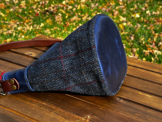 Harris Tweed® Lighthouse Crossbody round bag with flat bottom laying on side to show leather bottom