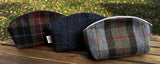 Three Seashell Pouch's in Red Green Black Plaid Harris Tweed®., Navy Window Pane Harris Tweed®. and Macleod Harris Tweed®.  The Seashell pouch has a curved top and flat base that stands up on its own and is lined with natural heavy canvas. 