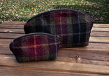 A large and small Seashell Pouch in Red Green Black Plaid Harris Tweed®.  The Seashell pouch has a curved top and flat base that stands up on its own and is lined with natural heavy canvas. 