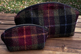 A large and small Seashell Pouch in Red Green Black Plaid Harris Tweed®.  The Seashell pouch has a curved top and flat base that stands up on its own and is lined with natural heavy canvas. 