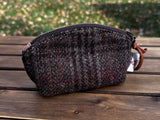 The Seashell Pouch in Warm Brown Harris Tweed® has a curved top and flat base that stands up on its own, lined with natural heavy canvas.