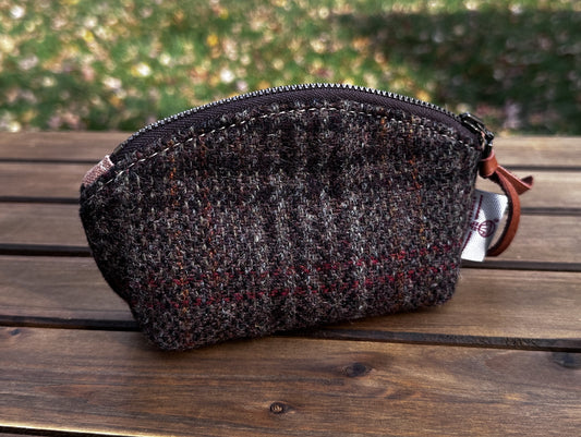 The Seashell Pouch in Warm Brown Harris Tweed® has a curved top and flat base that stands up on its own, lined with natural heavy canvas.