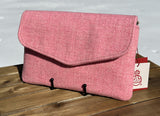 A vibrant blush pink Harris Tweed Skye Fold clutch, offering a soft and modern take on the timeless envelope silhouette. Perfect for adding a pop of color to an elegant ensemble.