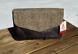 Close-up of a Skye Fold clutch in dark brown leather clutch with a herringbone Harris Tweed flap. Shows the clean lines and meticulous stitching of this handcrafted heritage piece.