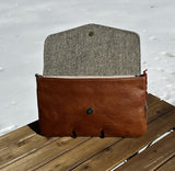 Interior view of an open Skye Fold clutch in Green and Beige Barleycorn Harris Tweed® with Sienna Leather The interior is spacious enough to fit a phone and daily essentials.