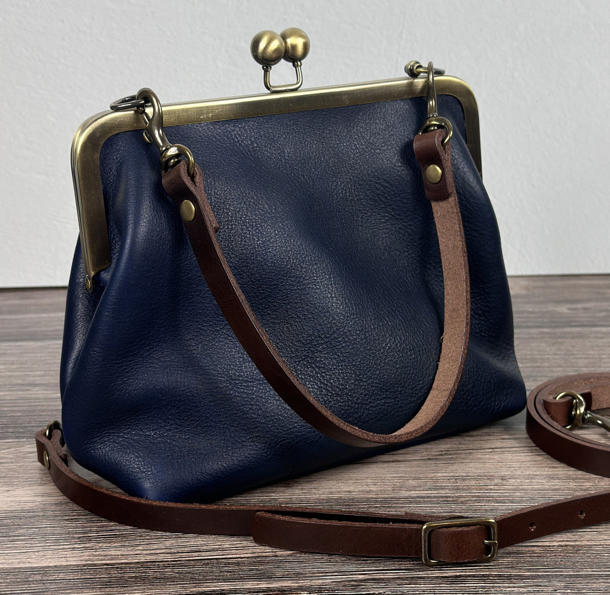 Handcrafted full-grain leather Princess Anne Kiss Lock handbag featuring a vintage-style frame and convertible straps.