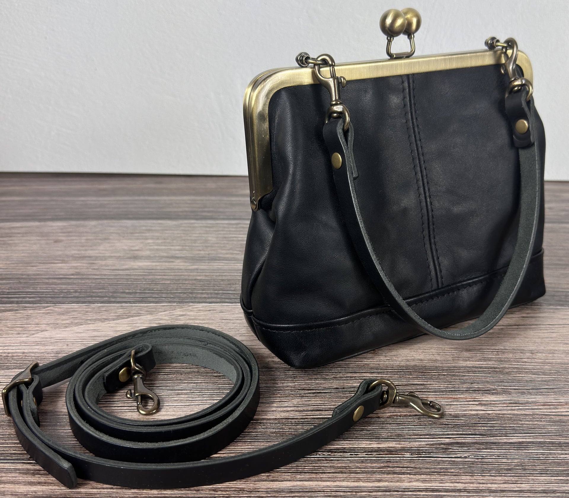 Handcrafted full-grain leather Princess Anne Kiss Lock handbag featuring a vintage-style frame and convertible straps.