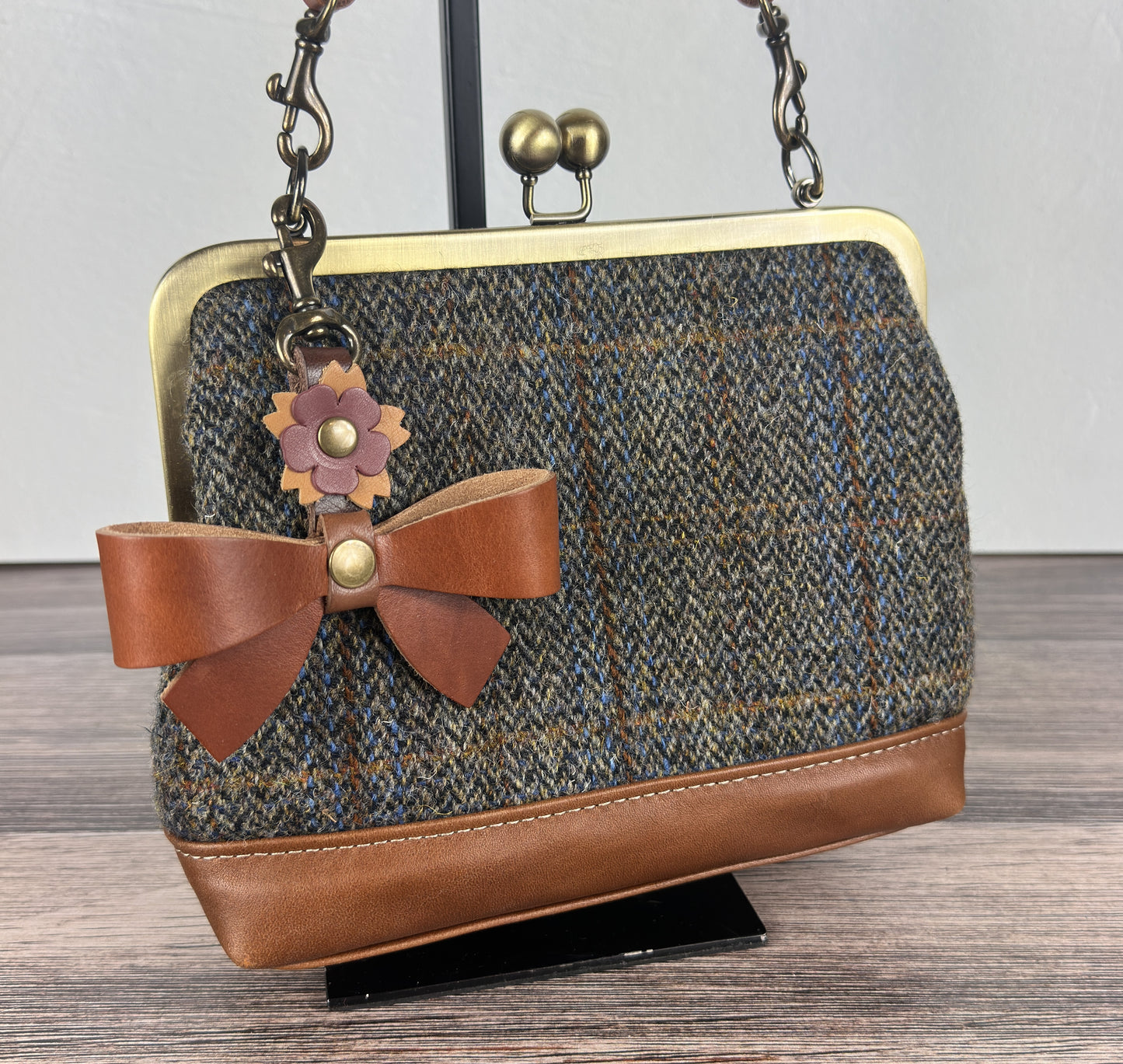 Leather bow bag charm clipped to Harris Tweed Princess Anne Kiss Lock Bag – handcrafted purse accessory cut by hand.