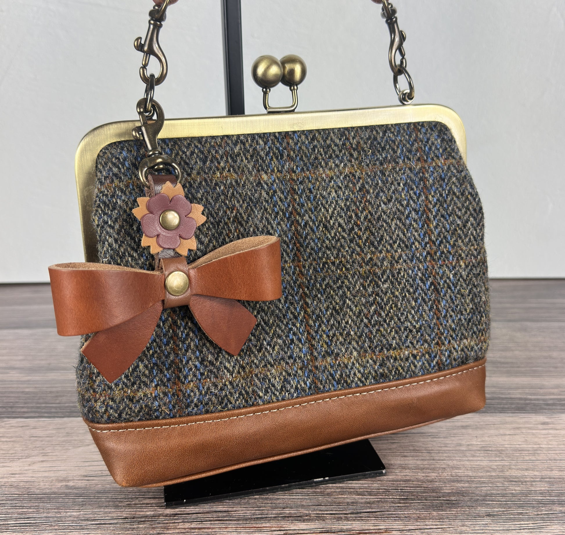 Leather bow bag charm clipped to Harris Tweed Princess Anne Kiss Lock Bag – handcrafted purse accessory cut by hand.