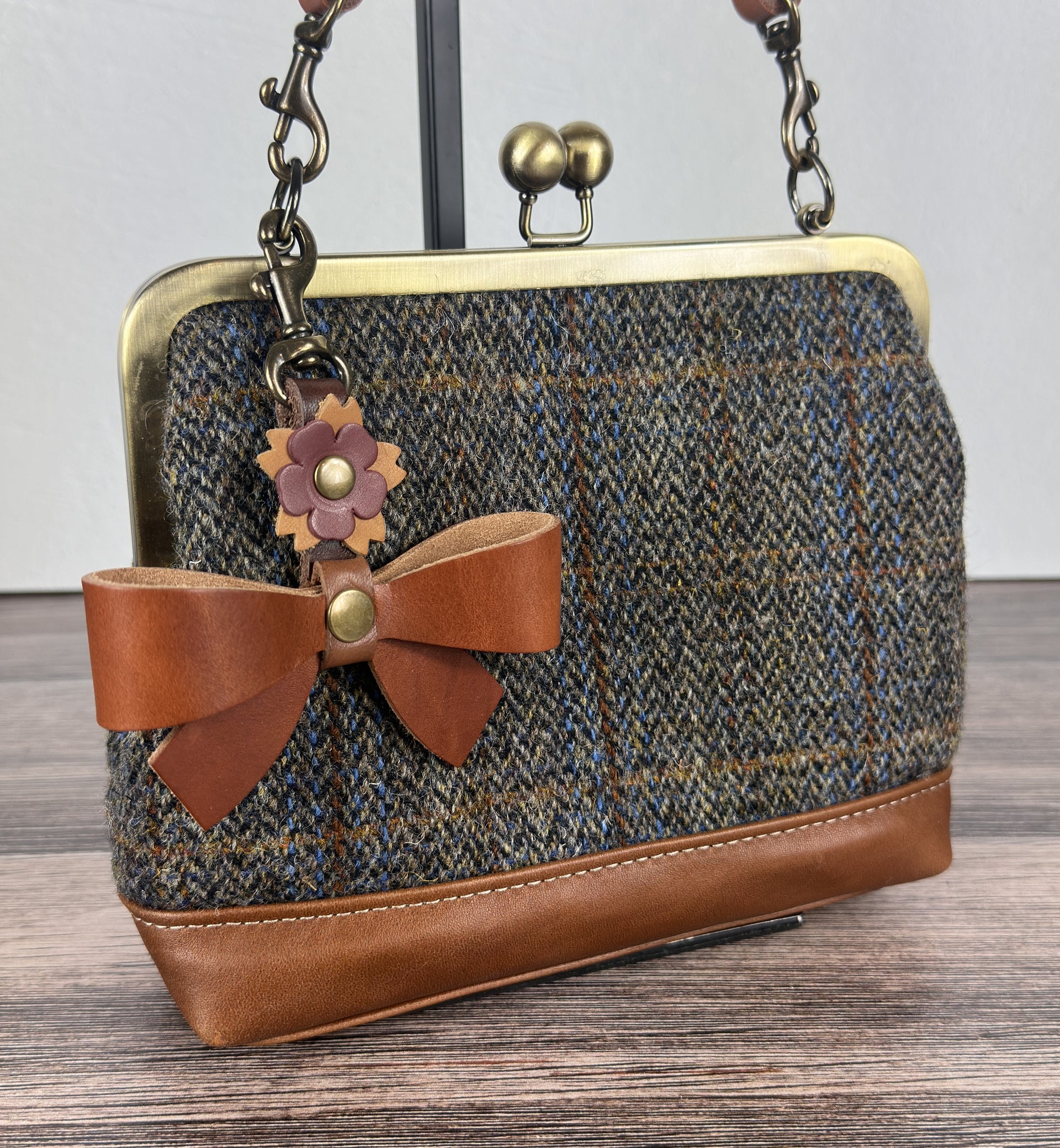 Leather bow bag charm clipped to Harris Tweed Princess Anne Kiss Lock Bag – handcrafted purse accessory cut by hand.