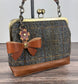 Leather bow bag charm clipped to Harris Tweed Princess Anne Kiss Lock Bag – handcrafted purse accessory cut by hand.